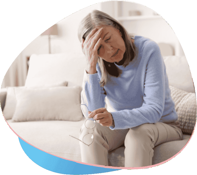 Senhora está sentada no sofá, sentindo fadiga